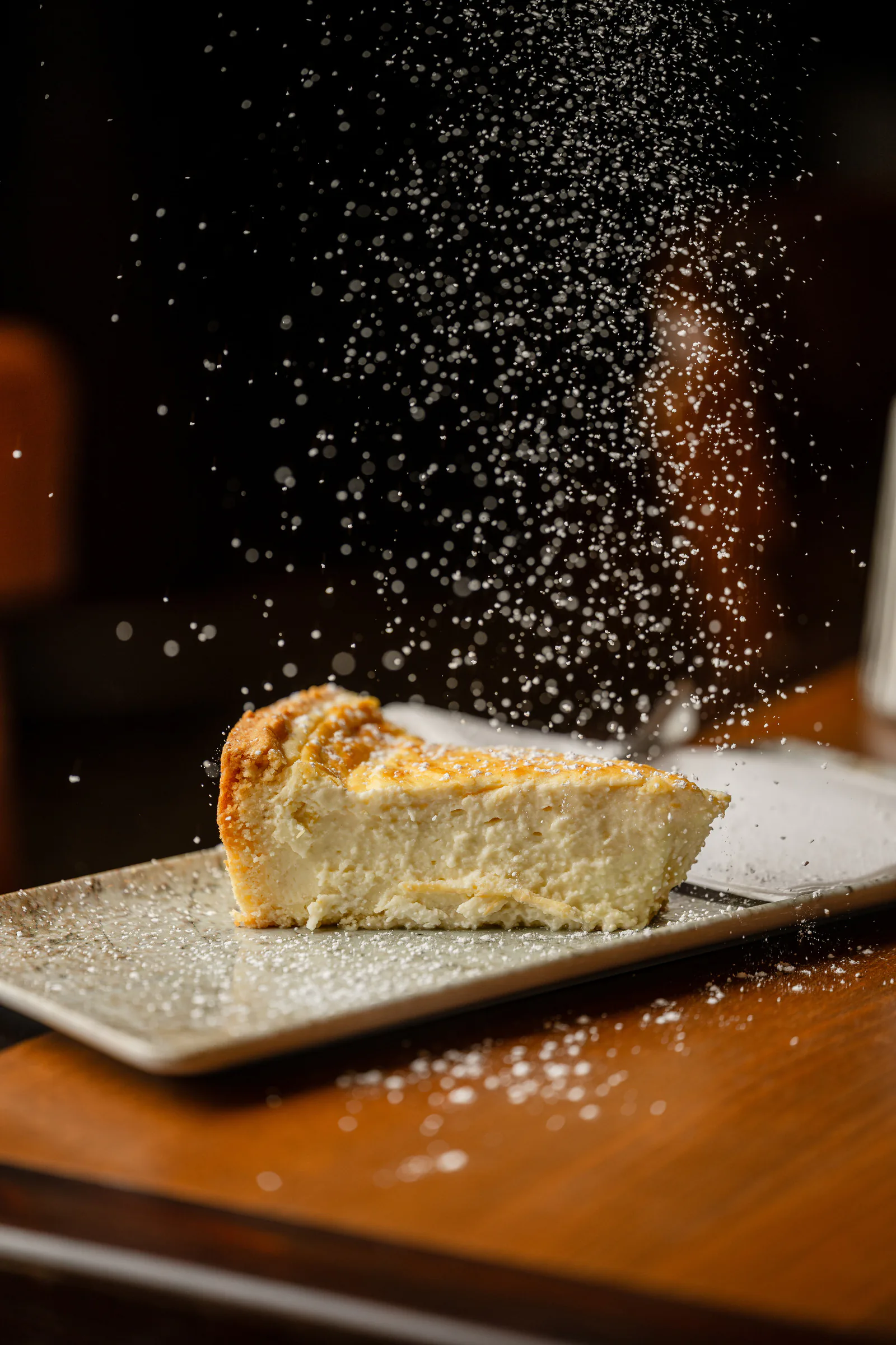 Hausgemachter Käsekuchen, mit Puderzucker bestäubt
