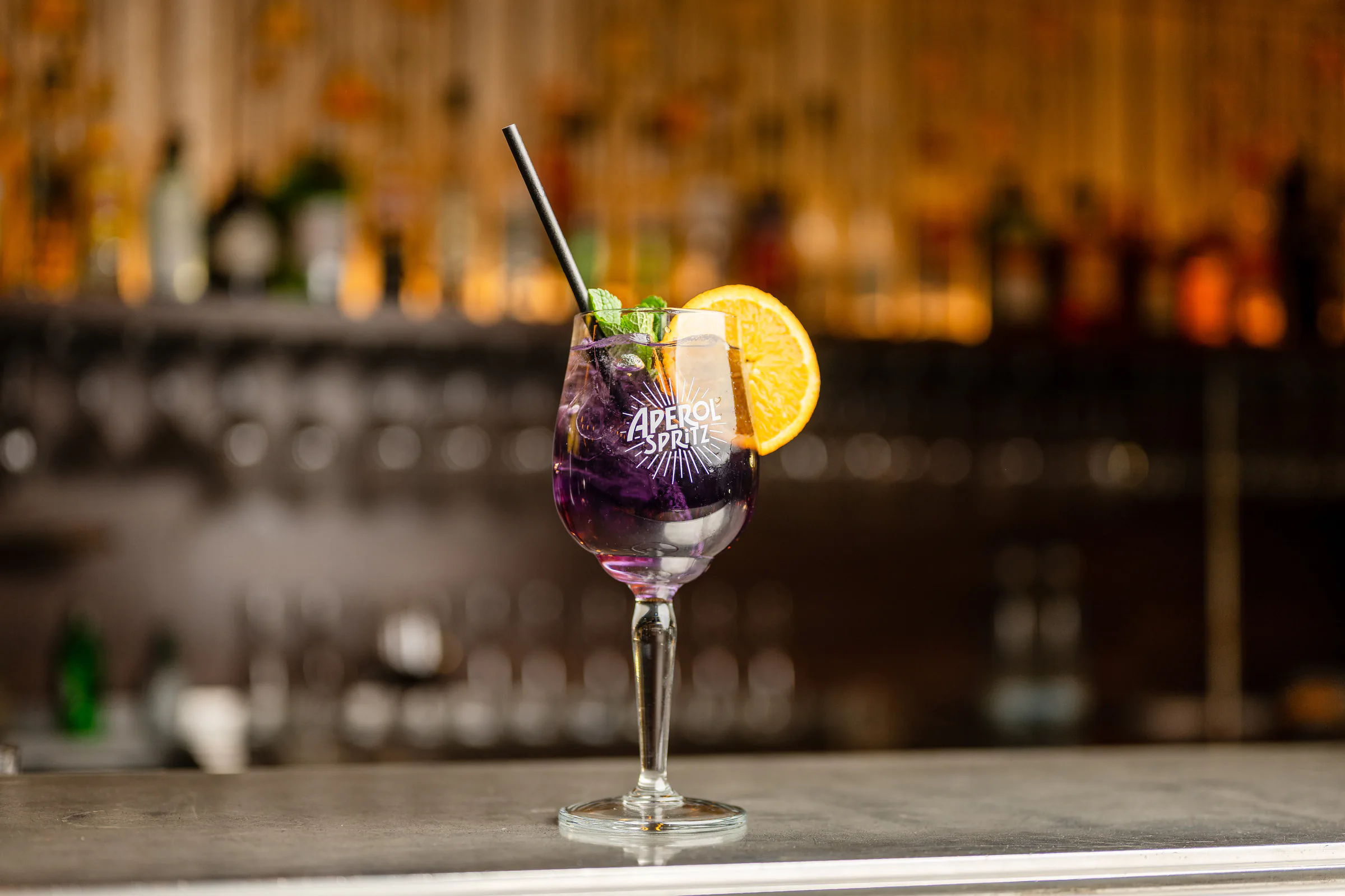Violetter Spritz am Tresen der Bar